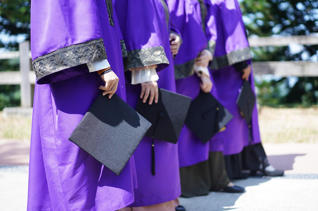 College graduation ceremony - students receiving diplomas after scholarship funding
