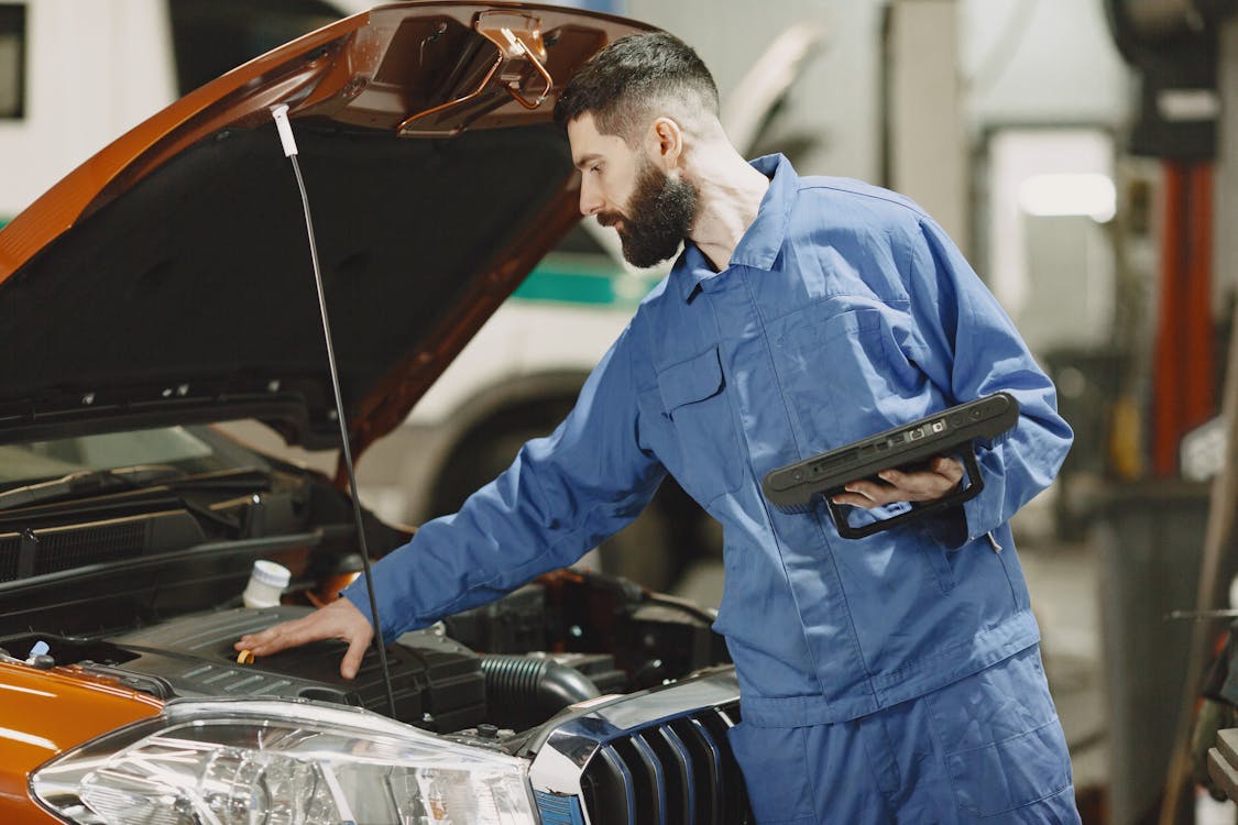 Mechanic checking the engine of a car during an inspection
