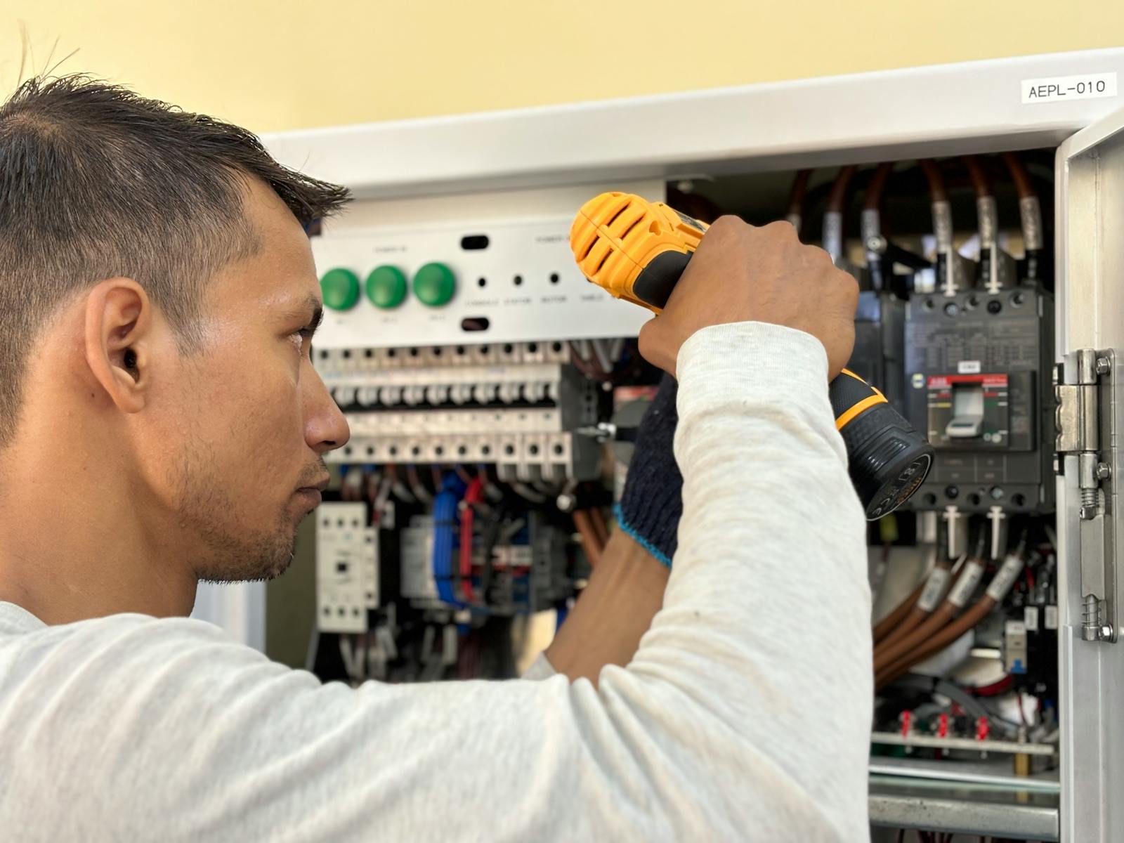 Electrician working on a residential electrical panel with wiring