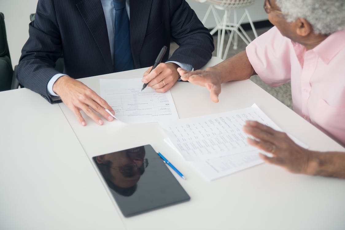 Elderly man consulting with an insurance agent about health coverage options including Medicare