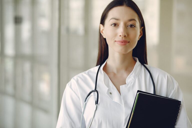 Young doctor in white coat with stethoscope ready to see patients
