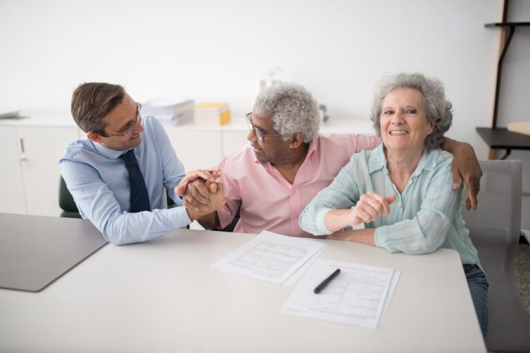 Insurance agent sitting with smiling clients discussing health insurance options