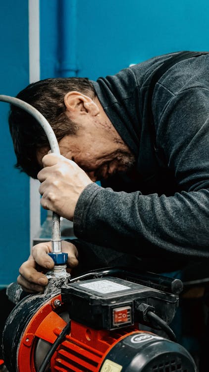 A professional plumber working on a water pump repair