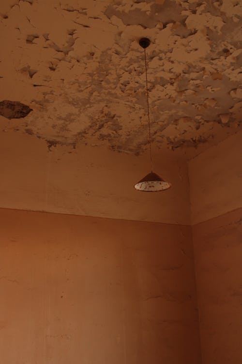 Water damage and peeling paint on a ceiling caused by a hidden water leak